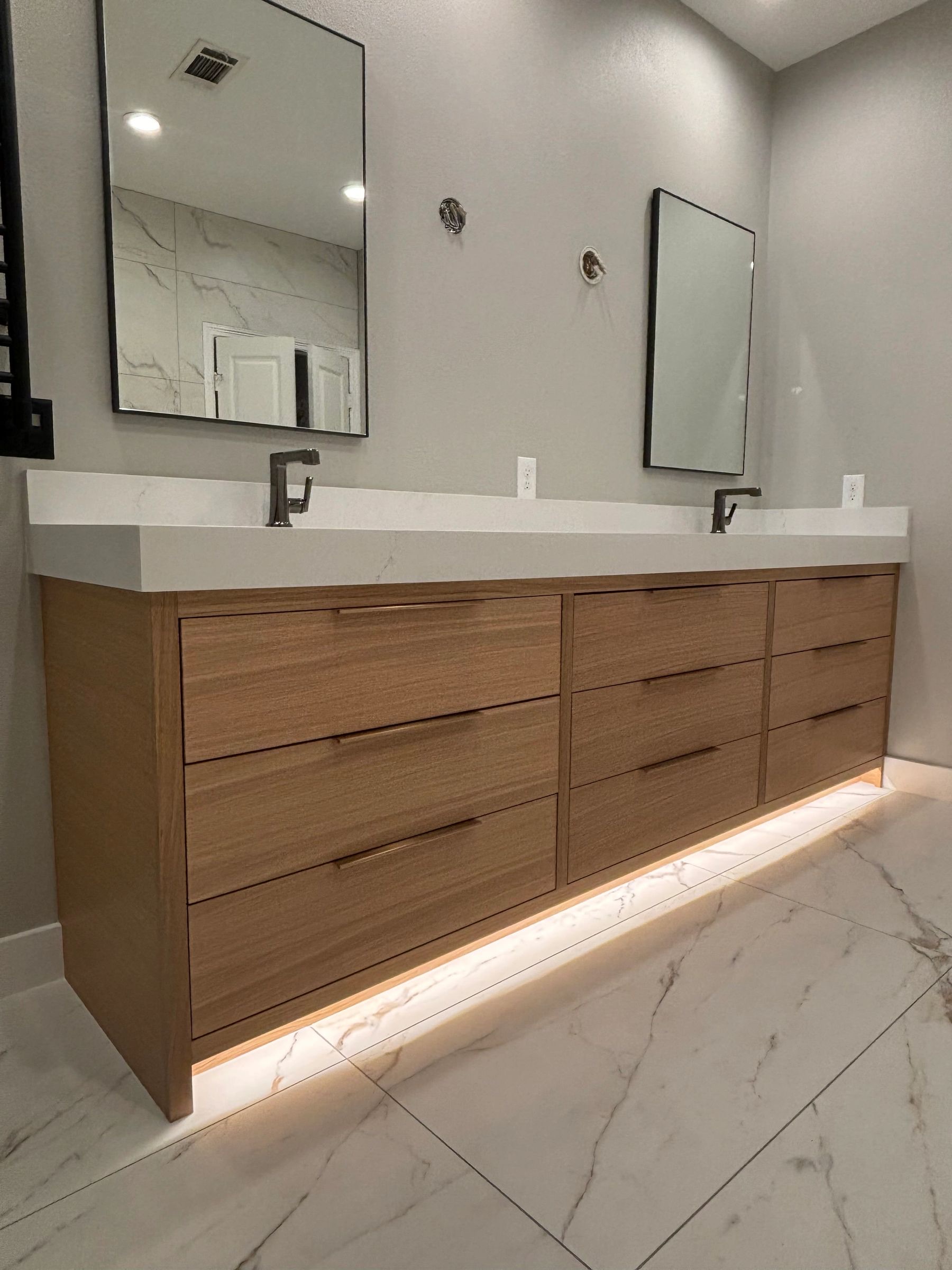 White oak floating double vanity with undermount lighting by Westcreek