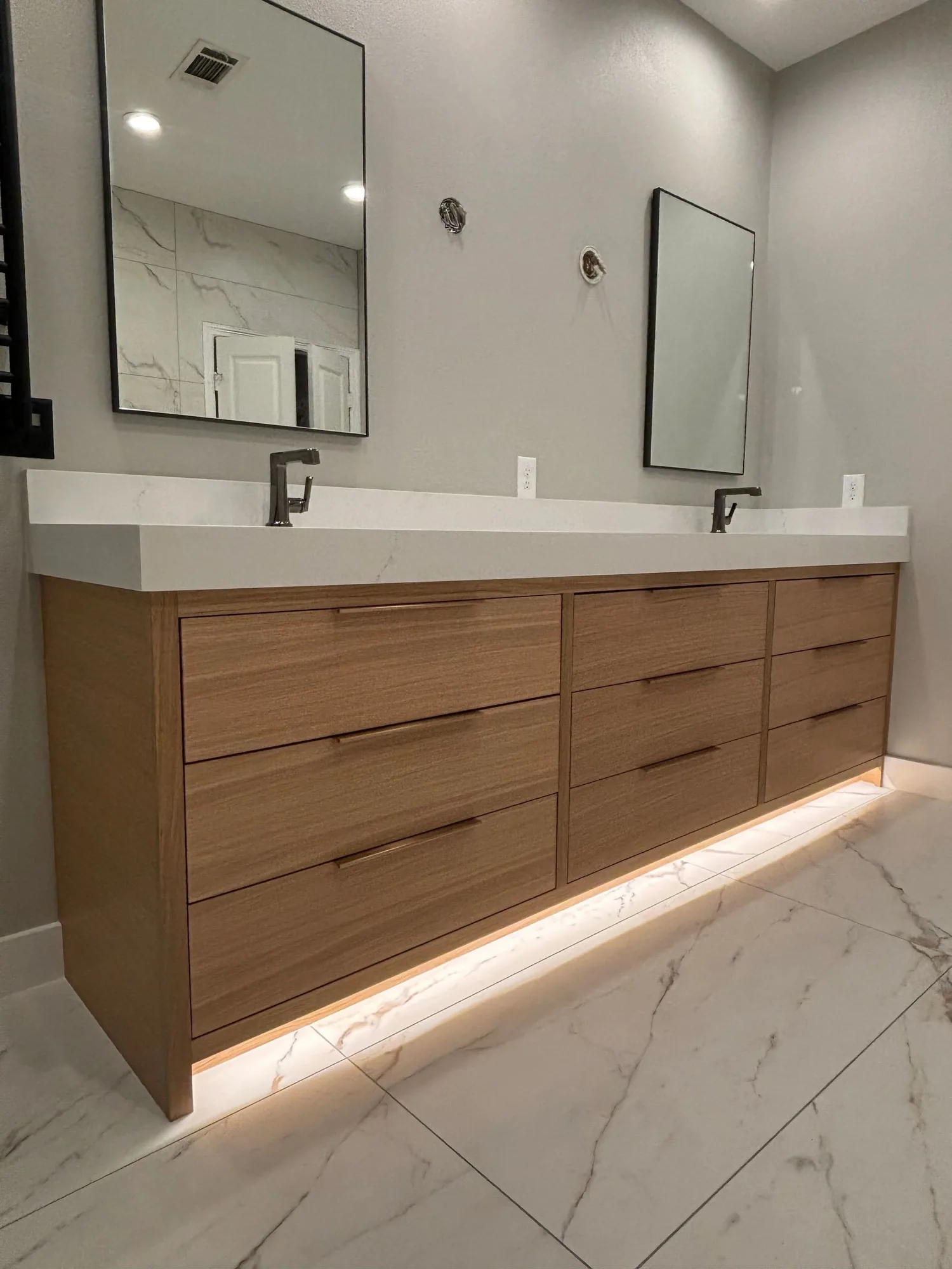 White oak floating double vanity with undermount lighting by Westcreek