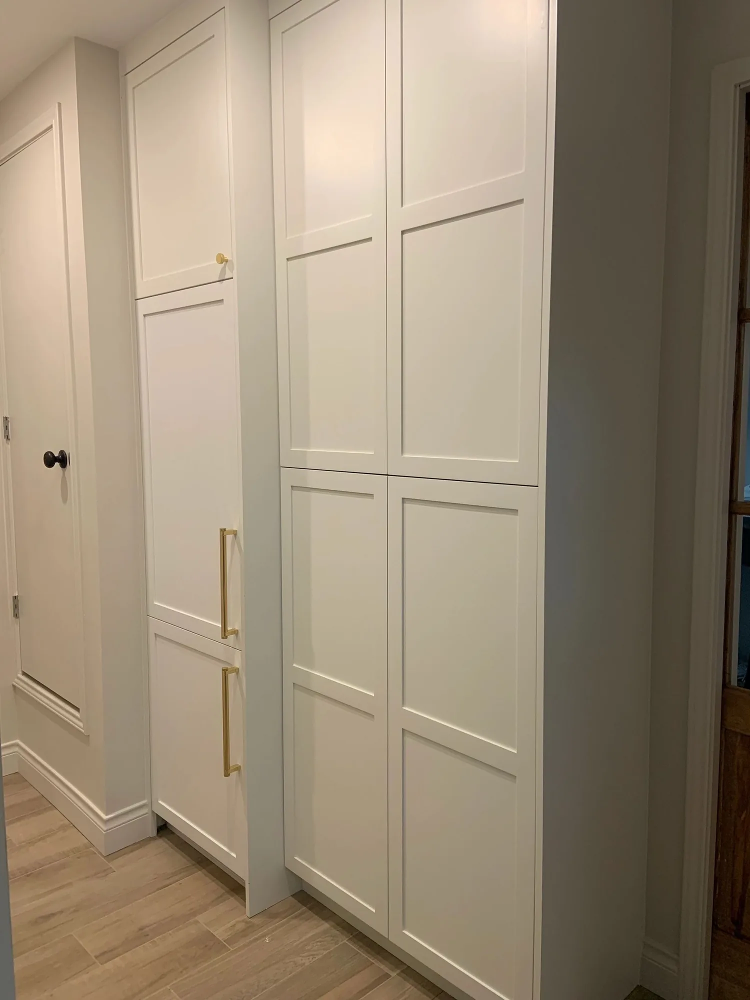 White shaker pantry cabinets with brass hardware by Westcreek
